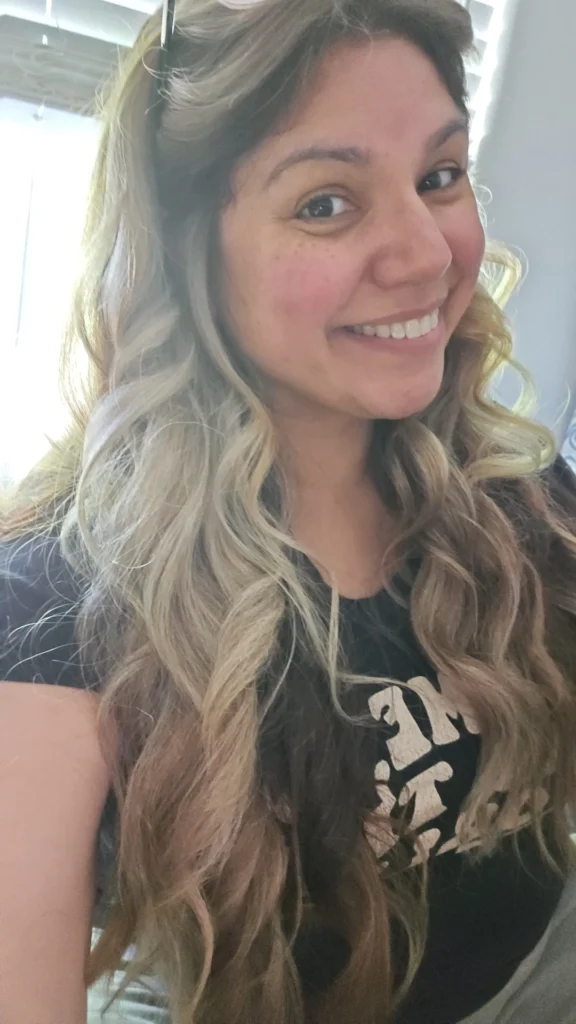 Smiling woman with long, wavy hair.